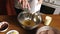 Woman adding oil in whisked eggs and mixing with electric mixer in the bowl