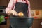 Woman adding onion with skins at chicken soup, chicken broth, in a pot.