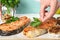 Woman adding parsley to cooked red fish on table, closeup