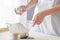 Woman adding salt to flour.