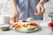 Woman adding sour cream to thin pancakes