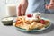 Woman adding sour cream to thin pancakes