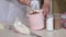 A woman adds cocoa to the cream for eclairs. Next to the jars are powdered sugar and cocoa powder. Medium plan