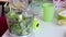 A woman adds milk and butter to a blender bowl with mint leaves and spinach. The process of making Swiss roll. Close-up shot