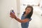 Woman Adjusting Digital Central Heating Thermostat At Home