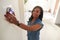 Woman Adjusting Digital Central Heating Thermostat At Home