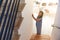 Woman Adjusting Digital Central Heating Thermostat At Home