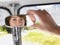 Woman Adjusting Rear View Mirror In Van