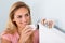 Woman Adjusting Thermostat With Bank Notes On Radiator