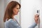 Woman Adjusting Thermostat On Central Heating