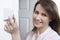 Woman Adjusting Thermostat On Central Heating Control