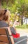 Woman adjusts her makeup in the park.