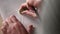 The woman adjusts the sketch with an eraser on her easel. Close-up of a hand with a pencil and an eraser