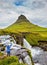 Woman admires the waterfall Kirkjufell Foss