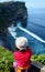 A woman admiring the beautiful Bali coastline and Uluwatu temple