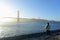 A woman admiring a beautiful view of the famous Golden Gate Bridge, on sunny evening during sunset, with a full view of the bay