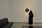 Woman admiring round shaped classic European painting in Louvre Abu Dhabi