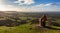 Woman admiring the view from the viewpoint on Coaley Peak, The Cotswolds, Gloucestershire, United Kingdom