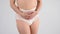 A woman in adult diapers holds her hands on her stomach. Urinary incontinence problem.