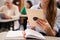 Woman at adult education class holding tablet, hands detail