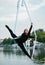 Woman aerialist performs gymnastic split on hanging aerial silk