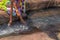 Woman in African outfit on the verge of fluent river. Interacting with water. Angola.