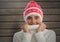 Woman against wood with warm woollen hat and jumper