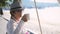 Woman in aged rests drinks coffee on swing on the beautiful beach