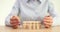 Woman agent holding hands of small wooden pawns closeup