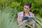 Woman agricultural expert standing in garden with tablet