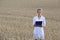 Woman agronomist or a scientist or a student with document in her hand in the wheat field