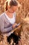 Woman agronomist or a student analyzing wheat ears