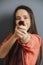 Woman aiming with a shower nozzle, blurred, focus on a cealed tip