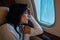 Woman with airsickness looking at airplane window in private jet