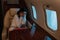 Woman with airsickness touching hair while sitting in private jet