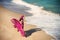 Woman in airy crimson dress on the beach