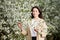 Woman allergic enjoying after treatment from seasonal allergy in front of blossom tree at spring.