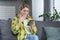 Woman alone at home, frustrated and shocked looking at the phone screen, sitting on the couch in the kitchen