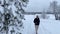A woman alone walks in a beautiful winter forest near a frozen lake in Russia