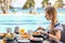 Woman on American Breakfast with Teapot on Table Next to Poolside in Resort