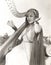 Woman in ancient Greek costume playing harp