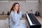 Woman angrily looks at home digital piano, problems learning to play musical instruments