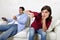 Woman angry and upset while husband or boyfriend plays videogames ignoring her