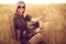 woman in animal print dress, straw hat in front of Sun in middle