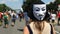 Woman with anonymous mask walking in protest