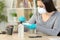 Woman applies sanitizer to disinfect phone due covid-19 at home