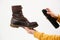 A woman applies the spray to brown nubuck women& x27;s winter boots. Water-repellent care for shoes, renewal and