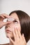 Woman apply eye drops. Girl glaucoma treatment