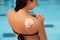 Woman apply sun cream protection on tanned shoulder. Beauty skincare sun aging protection body care