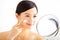 woman applying cream lotion on face